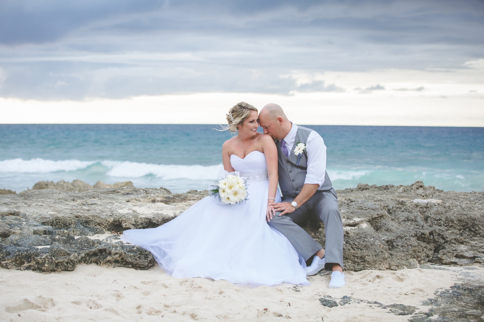 St. Croix wedding couple on beach sitting on rock