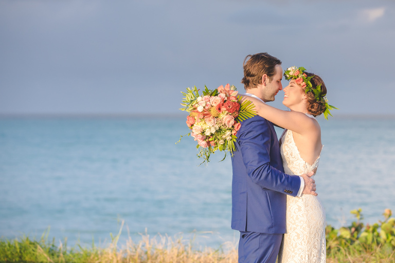 St. Croix bride and groom kissing on hillside overlooking the ocean