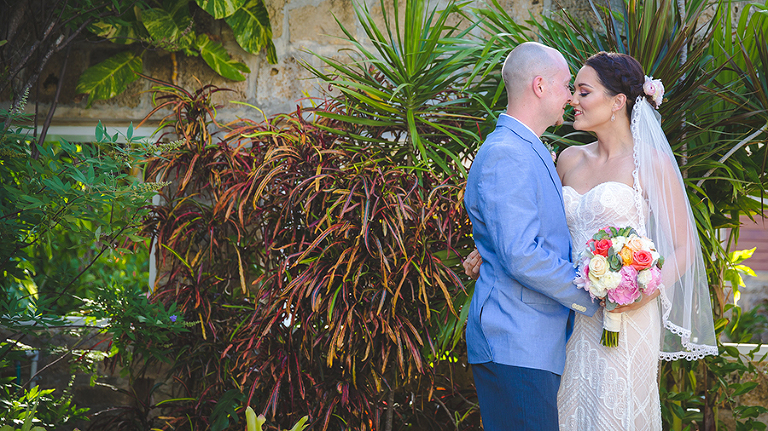 St. Croix Wedding couple kissing in front of tropical plants. 