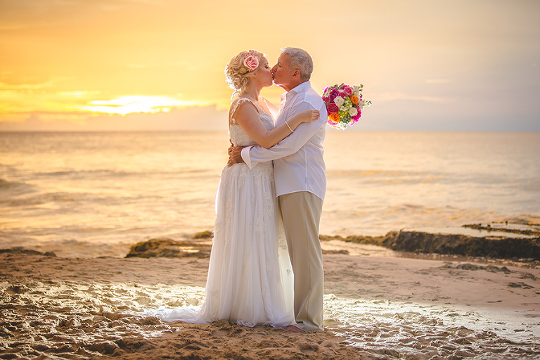 St. Croix wedding couple kissing on beach with amazing orange sunset 