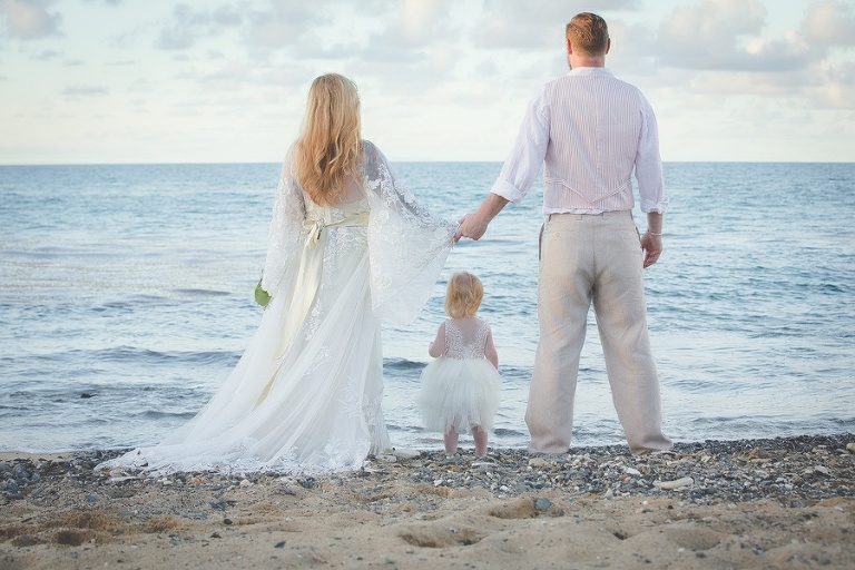 St. Croix bride and groom with child holding hands on beach